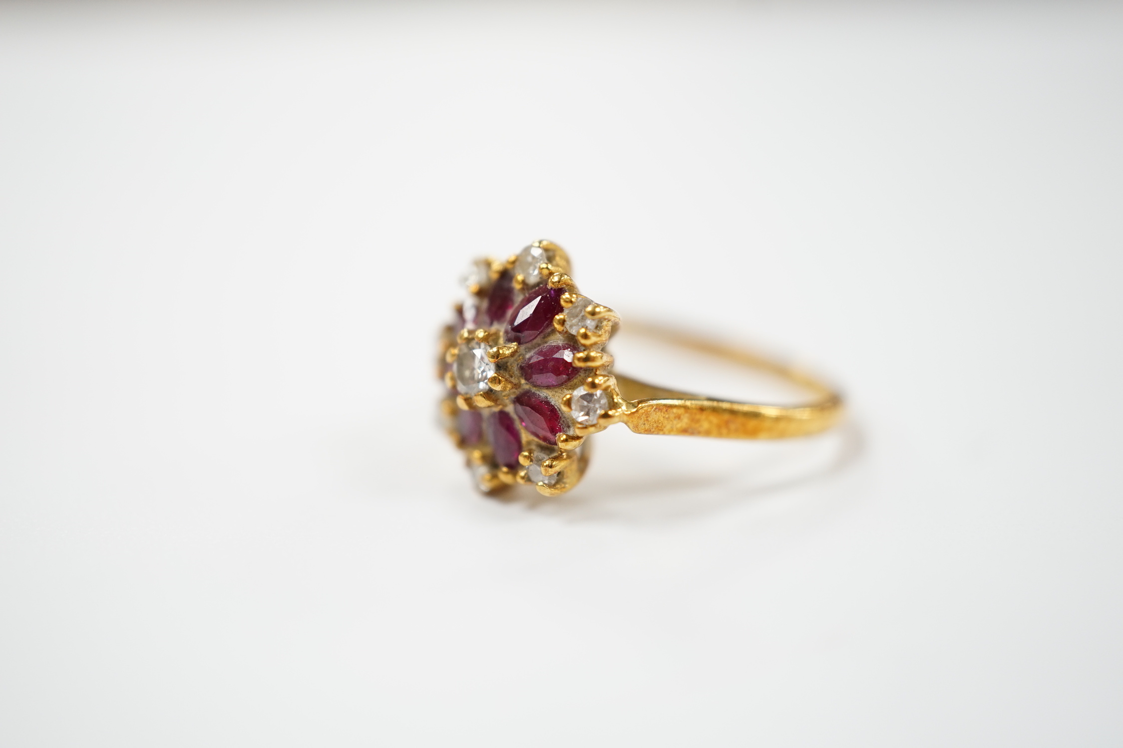 An 18ct, ruby and diamond set flower head cluster ring, size K, gross weight 3.7 grams.